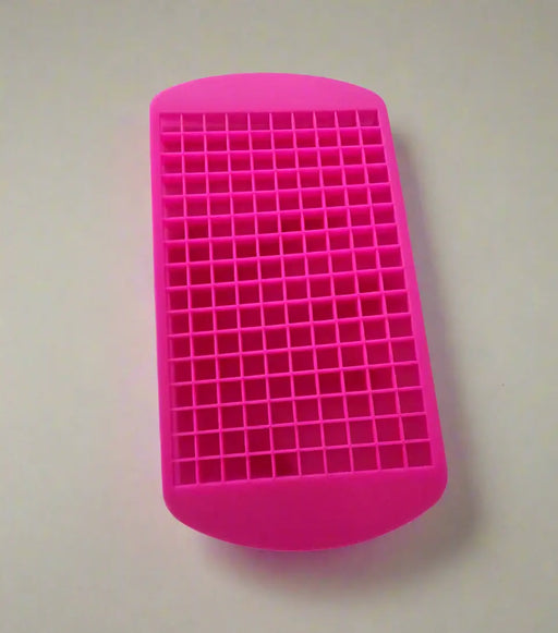 Pink silicone ice cube tray held by a hand on a tiled floor.
