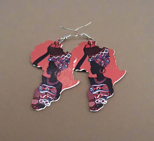 Red and black patterned earrings on a green surface