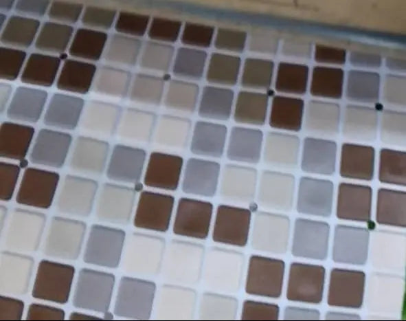 Close-up of a label with text on a tiled surface