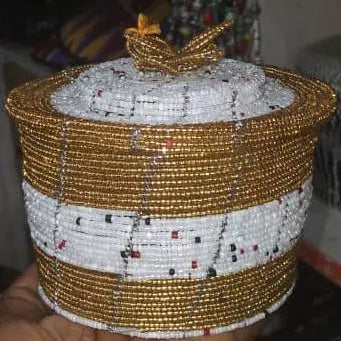 Hand holding a beaded container with a blurred background