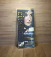 Hand holding a box of Citation hair color conditioner with a blurred background