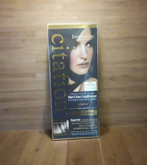 Hand holding a box of Citation hair color conditioner with a blurred background