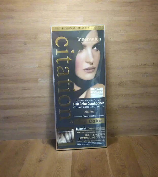 Hand holding a box of Citation hair color conditioner with a blurred background