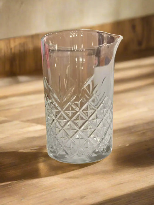 Clear glass vase with diamond pattern on a light-colored surface