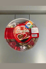 Container of Corazon chocolates held by a person in a store setting