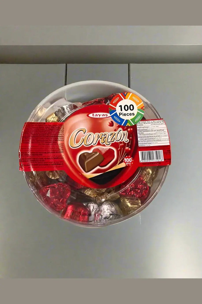 Container of Corazon chocolates held by a person in a store setting