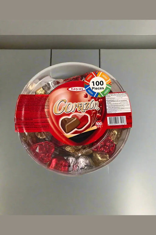 Container of Corazon chocolates held by a person in a store setting
