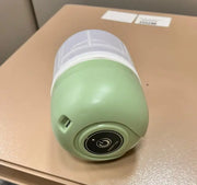 Green and white portable light on a beige surface