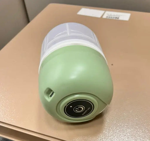 Green and white portable light on a beige surface