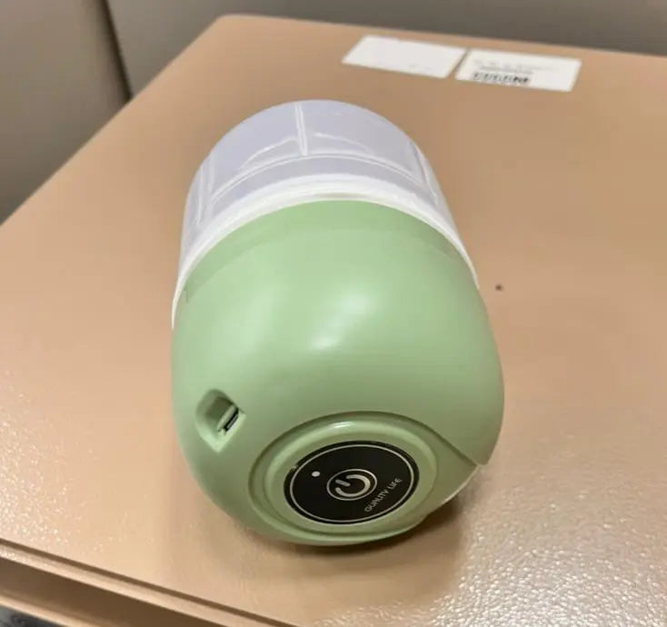 Green and white portable light on a beige surface