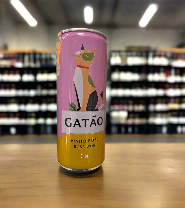 Canned rose wine with a cat design held by a hand in a grocery store setting