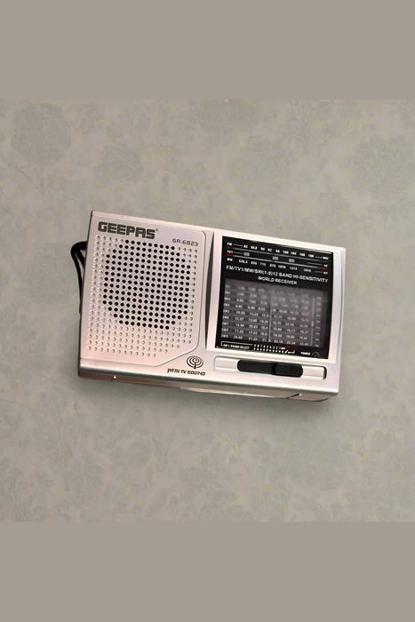 Hand holding a vintage-style radio on a tiled floor.