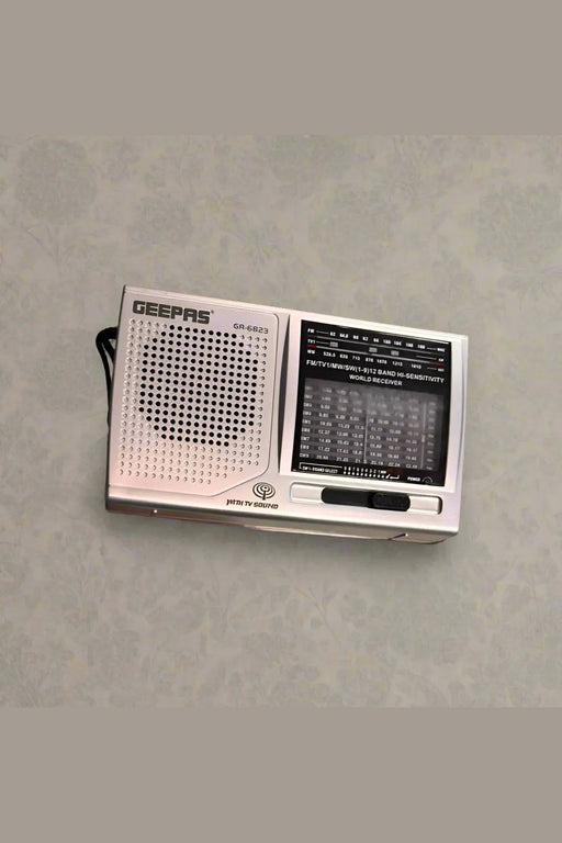 Hand holding a vintage-style radio on a tiled floor.