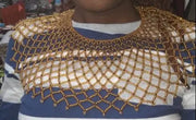 Woman wearing a striped shirt with a gold lace collar in a store setting
