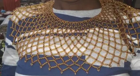 Woman wearing a striped shirt with a gold lace collar in a store setting