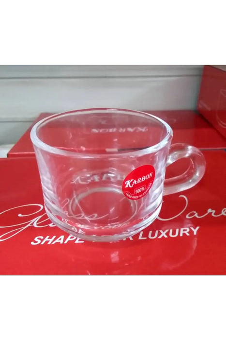 Clear glass mug with a red 'Karbon' label on a red surface