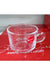 Clear glass mug with a red 'Karbon' label on a red surface