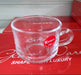 Clear glass mug with a red 'Karbon' label on a red surface