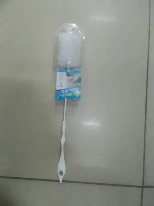 Cleaning brush with packaging on a tiled floor