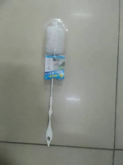 Cleaning brush with packaging on a tiled floor