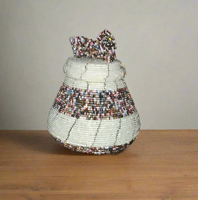 Hand holding a beaded decorative item with multicolored patterns