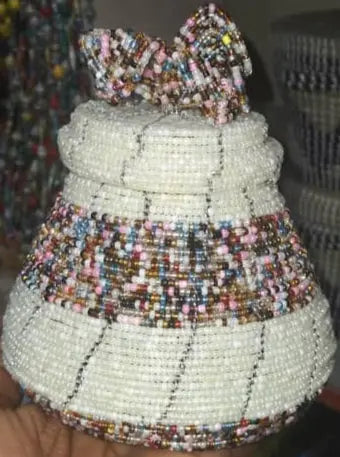 Hand holding a beaded decorative item with a blurred background
