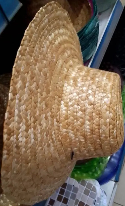 Woven straw hat on a blue surface with a blurred background