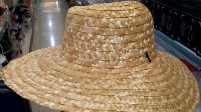 Straw hat held up in a store aisle