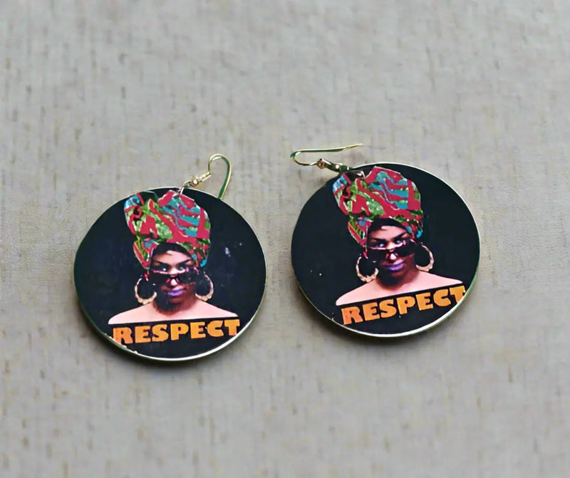 Two circular stickers with a person wearing a headwrap and 'RESPECT' text on a green surface.