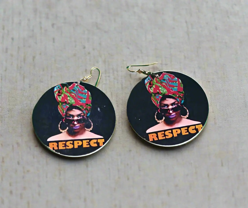 Two circular stickers with a person wearing a headwrap and 'RESPECT' text on a green surface.