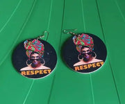 Two circular stickers with a person wearing a headwrap and 'RESPECT' text on a green surface.