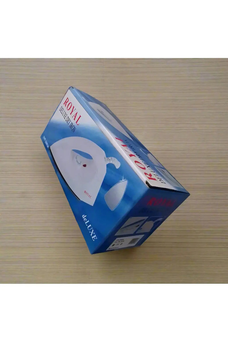 Hand holding a box of a Royal Deluxe iron on a tiled floor.