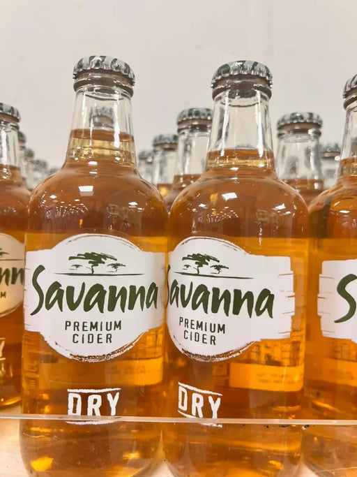 Bottles of Savanna Premium Cider with visible labels on a reflective surface.