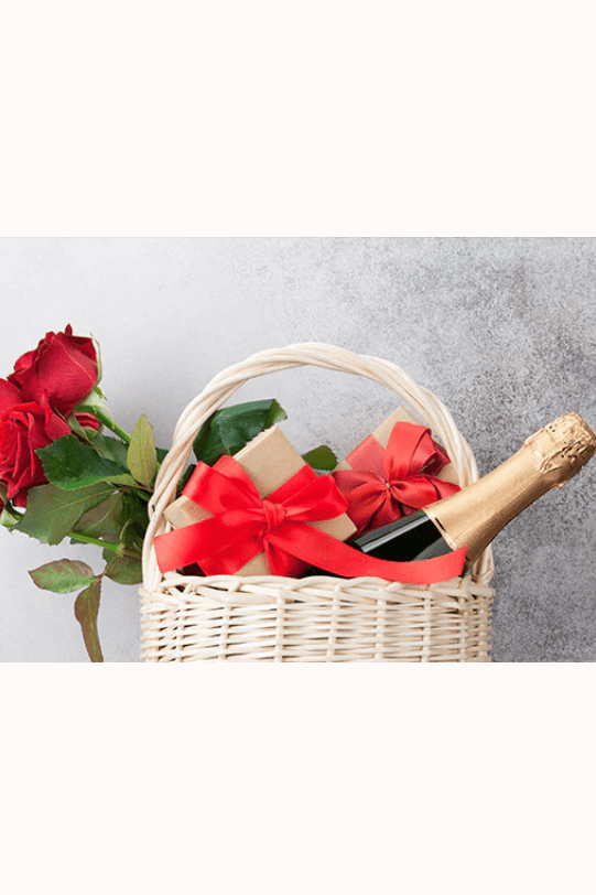 Gift basket with Wrapped Crackers, a bottle of champagne, and bunch of roses
