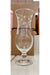 Clear glass with a stem on a store shelf with boxes in the background