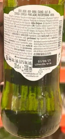Hand holding a green beer bottle with a label in front of a shelf of beer bottles.