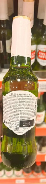 Hand holding a green beer bottle with a label in front of a shelf of beer bottles.