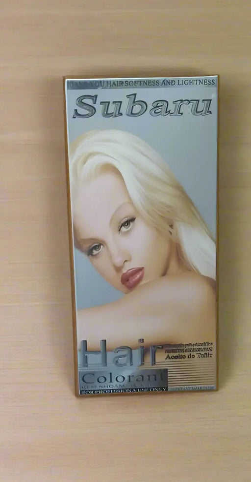 Hair colorant box with a person's hand holding it, on a tiled floor.