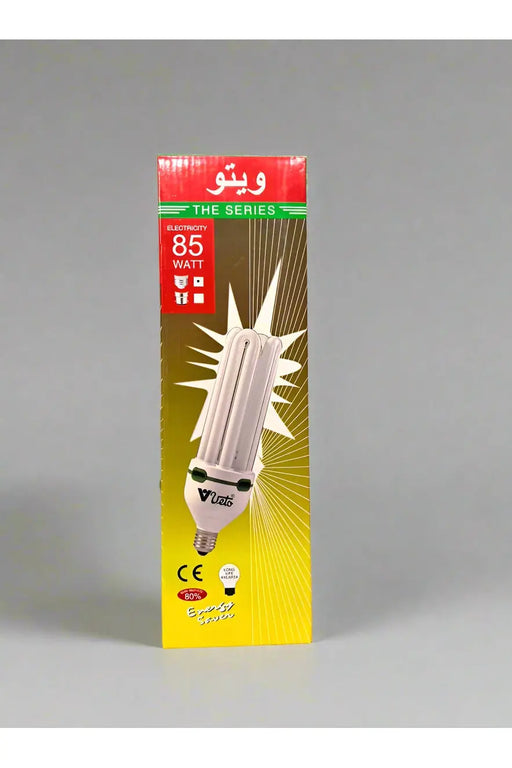 Hand holding a packaged energy-saving light bulb in a store setting