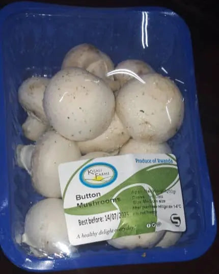 Packaged button mushrooms with a visible label on a dark surface