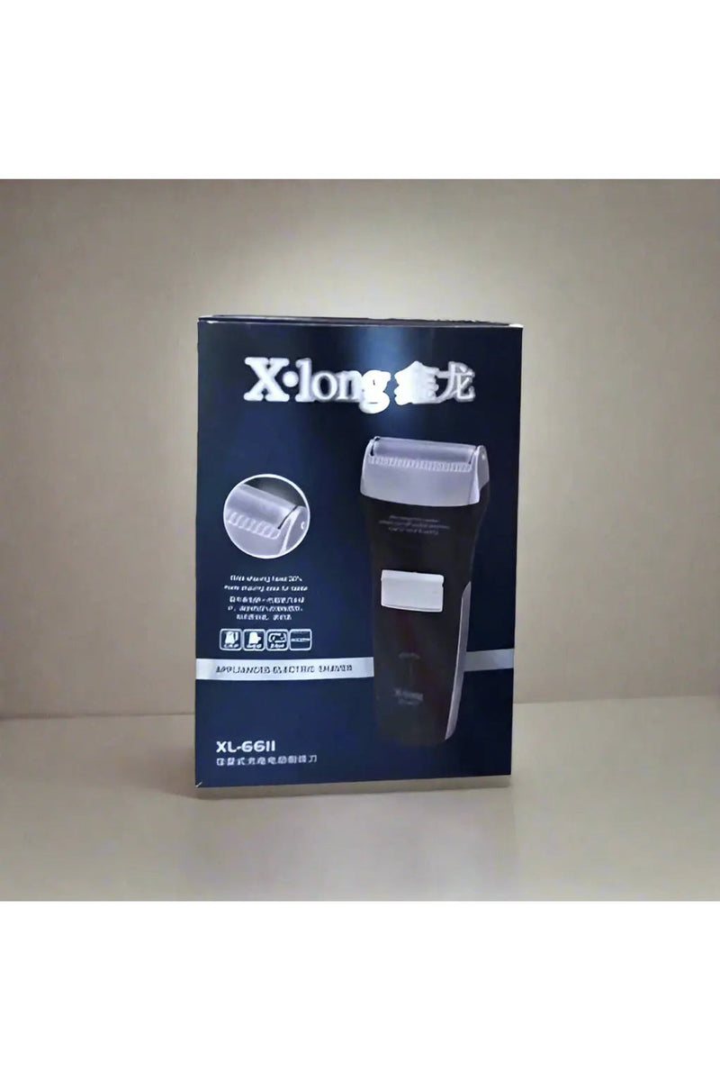 X-long electric shaver box held by a hand on a tiled floor.