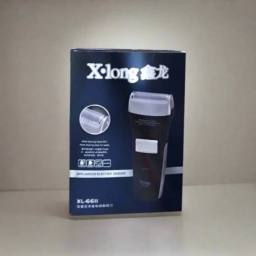 X-long electric shaver box held by a hand on a tiled floor.