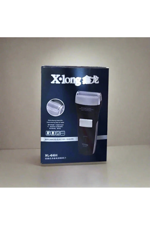 X-long electric shaver box held by a hand on a tiled floor.