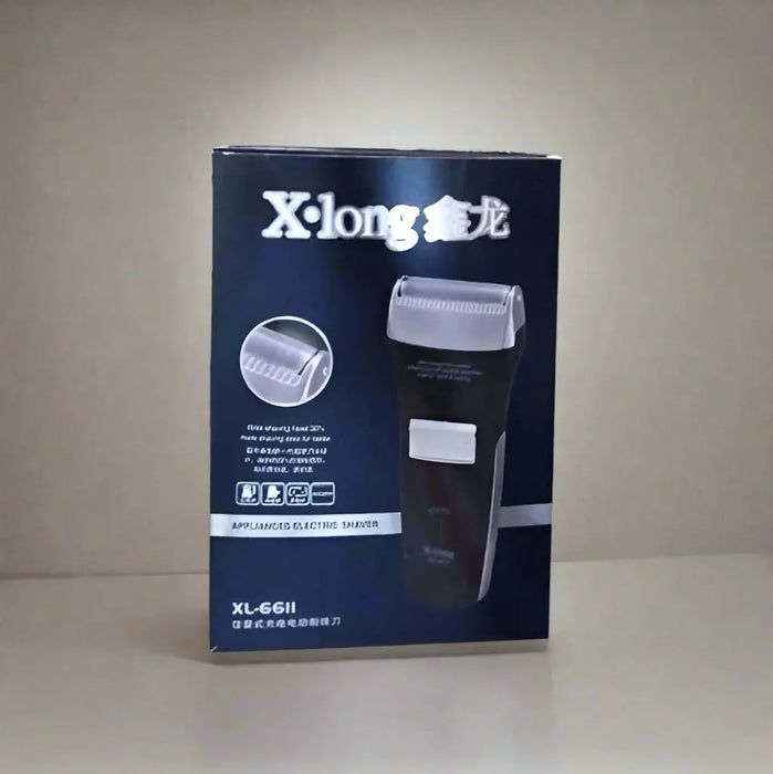 X-long electric shaver box held by a hand on a tiled floor.