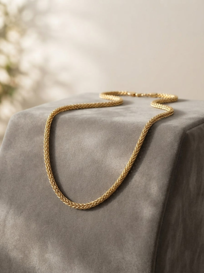 "A sleek and intricately woven gold chain 50 gm